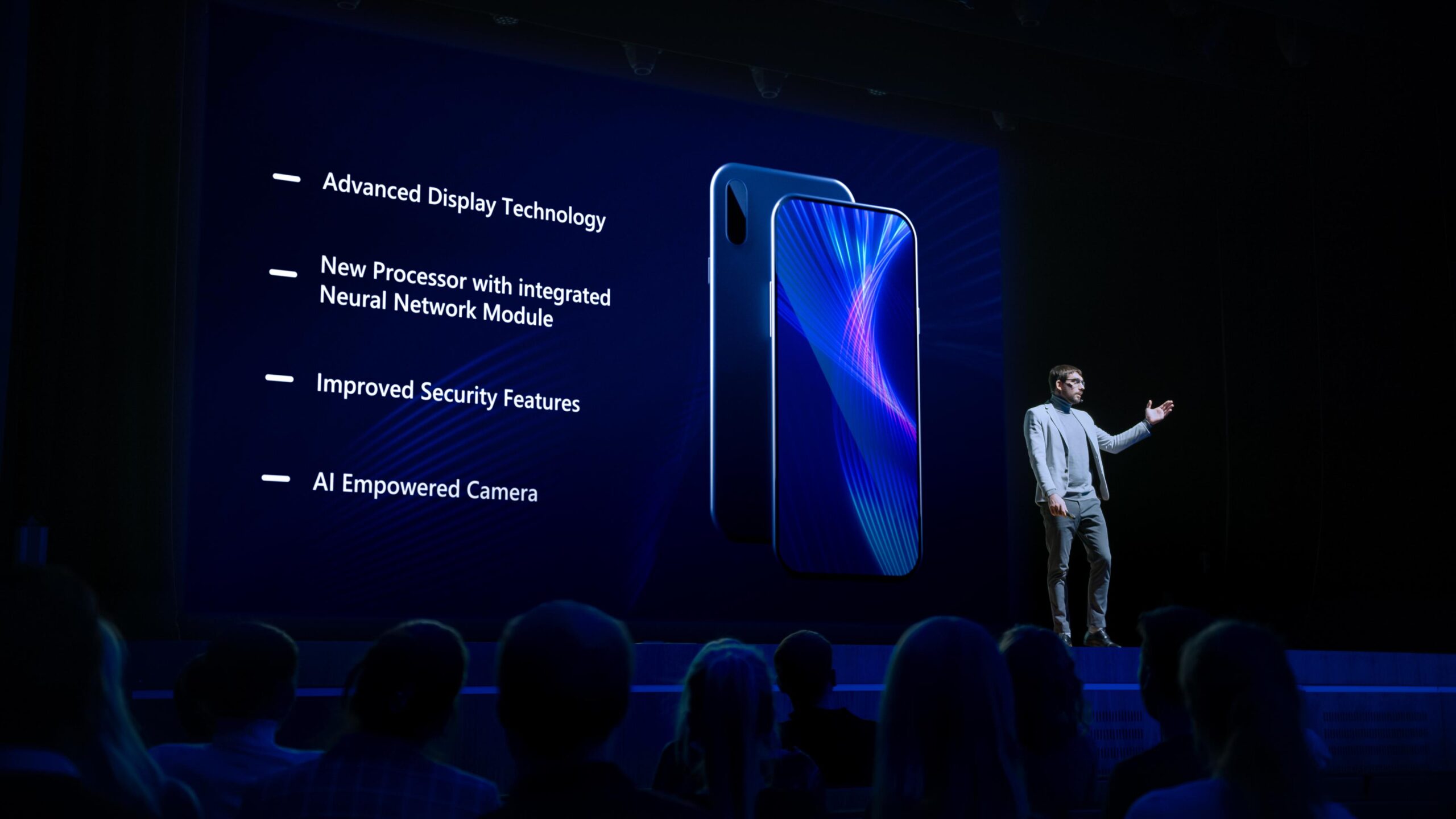 A presenter showcases a new smartphone with advanced display, neural processor, enhanced security, and AI camera. Audience watches.