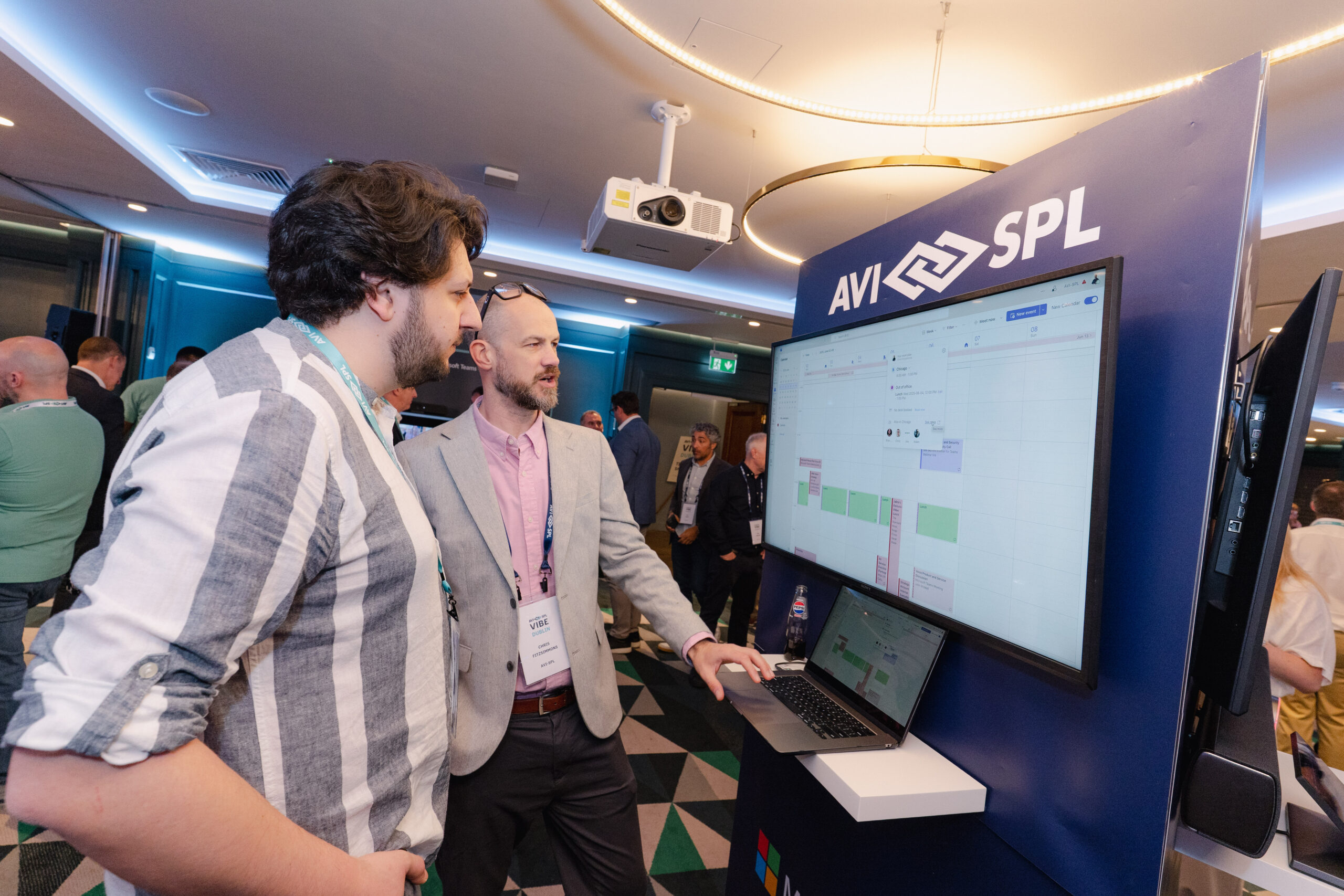 AVI-SPL team member talking to customer in our tech expo at a customer event