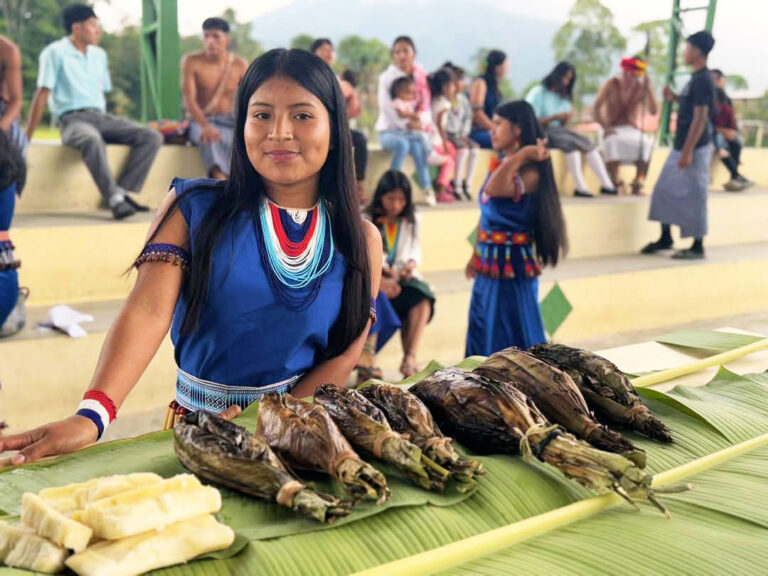 Shuar woman displaying food on a table